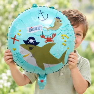 Boy holding Ahoy Pirate Shark Foil Balloon 18 inch against a pale background