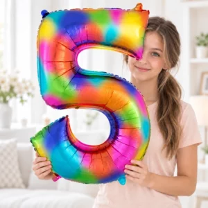 Girl holding a rainbow number 5 foil balloon against a pale background