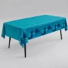 Teal tablecover with dark blue shark silhouette borders draped over a rectangular table on a grey background